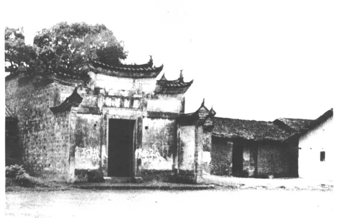 带马头墙门楼的旧祠堂建筑与旁边平房的黑白照片