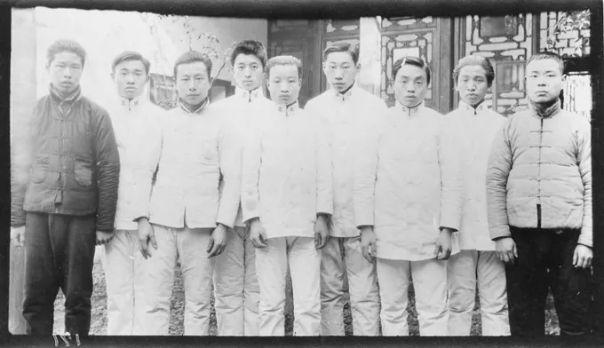 一群男性护士与见习学生站在建筑前合影
